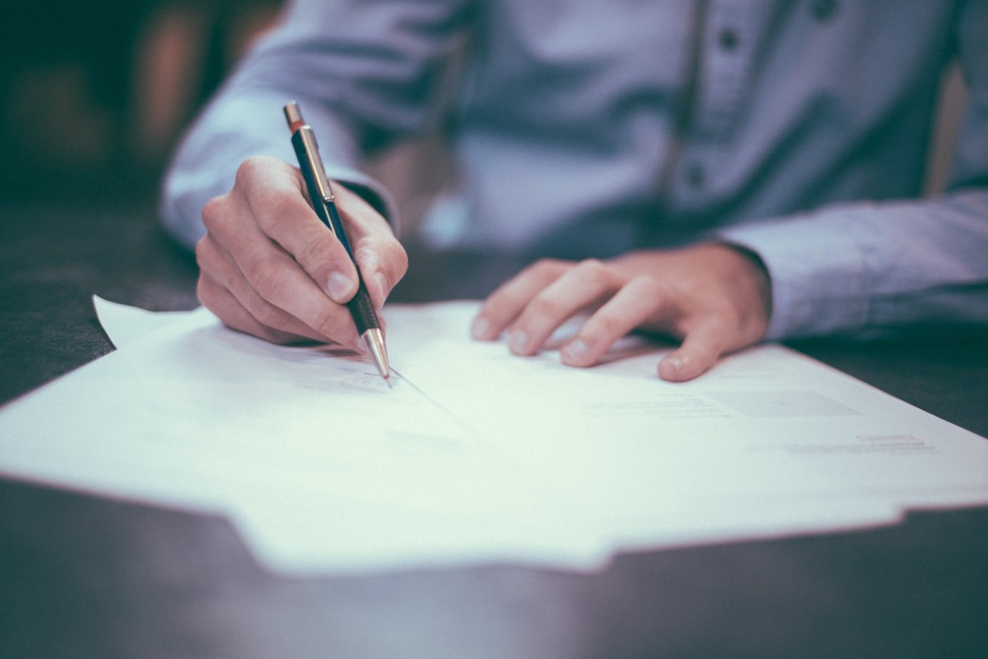 Signing and reviewing paperwork on a desk